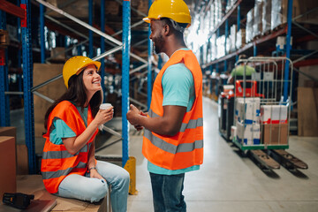 Warehouse workers chatting during coffee break in distribution center