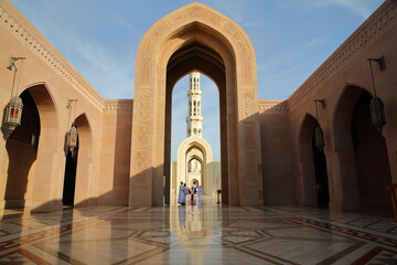 The main entrance to Sultan Qaboos Grand Mosque for Muslims in Muscat, Oman, with patterned tiles and reflections