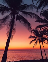 Multiple palm trees create a striking silhouette against a vibrant orange and pink sunrise over the tranquil ocean, evoking feelings of relaxation, vacation, and escape to a tropical paradise