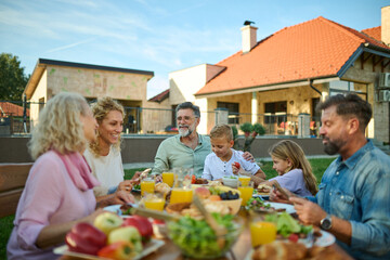 Happy extended family having lunch together on a sunny day