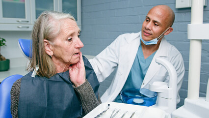 Obraz premium Elderly Woman Visiting Dentist Expressing Concern About Teeth