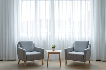 Two armchairs and small table by bright window with sheer curtains.