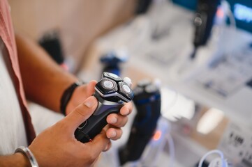 Indian Man choosing trimmer at electric store