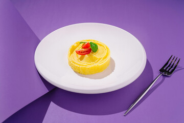 Creamy mashed potatoes topped with cherry tomatoes and fresh herbs on a vibrant purple background