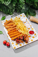 Delicious platter of chicken, fries, and snacks arranged on a colorful plate