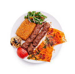 Delightful platter featuring grilled skewers, bulgur, and fresh herbs served on a white plate