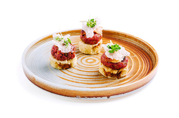 Delightful plated hors d'oeuvres showcasing beef tartare on crunchy bases with fresh garnishes