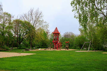 A playground with a bright red play tower and slide in Königsbrunn near Augsburg in Bavaria on a...