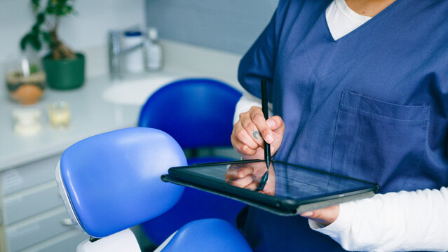 Healthcare Professional Using Tablet in Modern Dental Office - Powered by Adobe