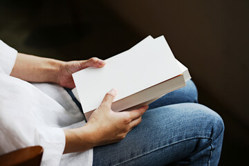 Woman sitting on a chair with a book in her hand