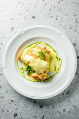 Delicious pancakes rolled and drizzled with creamy sauce, garnished with fresh greens. A visually appealing dish perfect for breakfast or brunch settings. Ideal for food-related projects.