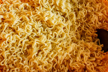 A close-up image of cooked instant noodles. The noodles are light yellow and look appetizing. Close-up shot of cooked instant noodles, a simple yet satisfying meal.