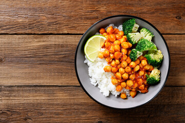 Chickpea curry with basmati rice and broccoli on wooden background, top view