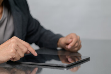 Person interacting with tablet device on reflective surface
