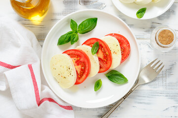 Caprese salad with fresh tomatoes, mozzarella cheese and basil. top view