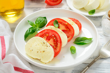 Caprese salad with fresh tomatoes, mozzarella cheese and basil.