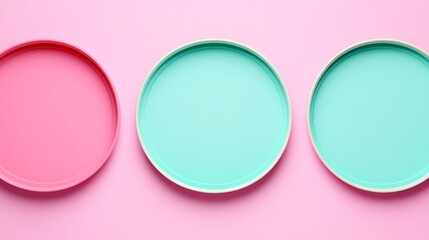 Obraz premium Colorful Round Plates in Pink and Mint Green Arranged on a Soft Pink Background for Contemporary Table Settings