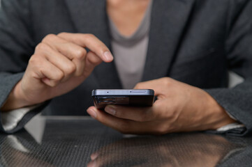 Person Using Smartphone While Sitting at Table in Business Attire