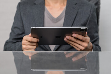 Person Holding Tablet in Stylish Office Setting with Reflection