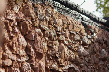 
a stone wall made of stones of various sizes and colored in a reddish-brown shade.