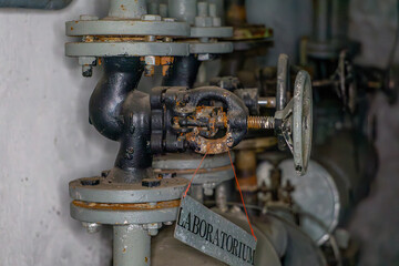 old rusty pipes, central heating valves in the boiler room in an old abandoned production plant. pipe connections.