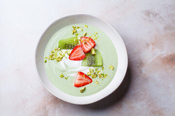 Green matcha yogurt with berries and pistachio. Vegan breakfast concept.