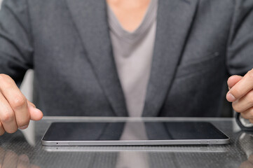 Hands of a Business Person on a Sleek Tablet Device at Desk
