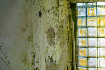 concrete texture, old wall with cracks and scratches. peeling paint on the wall of an old abandoned building. destruction of paints and plasters by moisture. green mold and fungi on the wall
