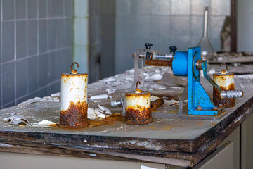 old tools in an abandoned chemical laboratory. rusty weights. dirty laboratory work table.