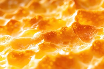 A close-up view of golden, bubbling cheese, showcasing its rich texture and appetizing color, perfect for culinary delights.