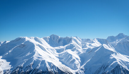 Fototapeta premium A stunning view of a snow-covered mountain range under a bright blue sky, capturing the peaceful and breathtaking beauty of winter, with untouched white peaks creating a serene and majestic landscape.