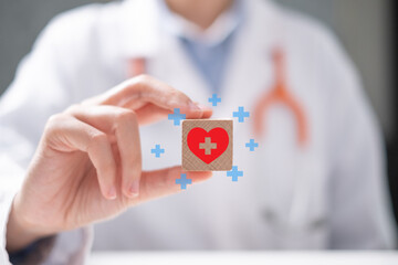 Professional healthcare worker doctor physician holding red heart icon on wooden block care organ donation concept