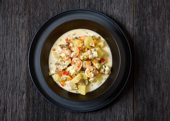 seafood chowder in a white bowl, top view