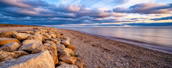 Sunset over ocean nature concept. A serene beach scene at sunset with rocks and gentle waves under a colorful sky.
