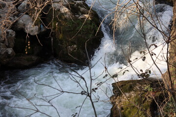 A powerful river surging with intensity, creating white foam as it flows