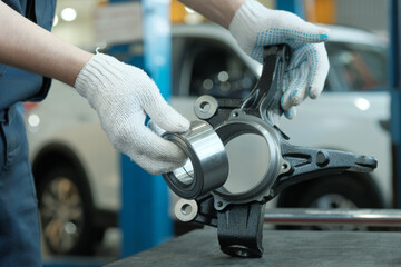 Repair of a car's front suspension at a car service center.The mechanic controls the new right...