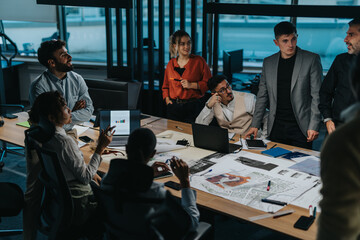 A diverse group of business people engaged in a brainstorming session. They are working together on...