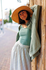 Obraz premium Young girl smiling happy standing at the city. portrait of a beautiful brunette in stylish summer clothes. Cheerful young woman smiling on the street during vacation.