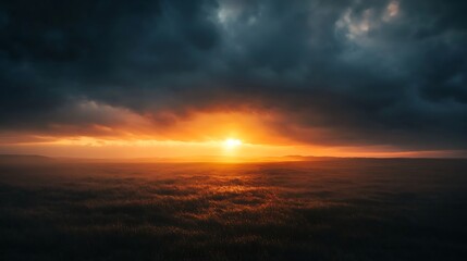 Dramatic sunset over misty field with dark clouds.