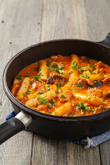 Traditional Korean Tteokbokki rice noodles with chicken, vegetables and shitake mushrooms. Prepared in a pan.