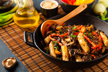 Traditional Korean Tteokbokki rice noodles with beef, vegetables and shitake mushrooms. Prepared in a wok.