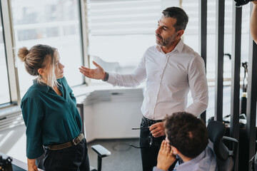 Fototapeta premium A group of business workers engaged in discussion at the office. The image captures leadership and teamwork dynamics among business employees and professionals in a modern work environment.
