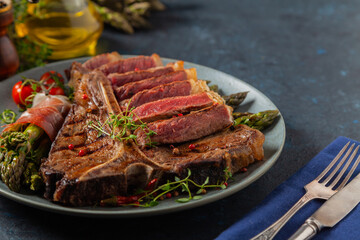 Grilled, medium-baked t-bone beef steak. Served with asparagus.