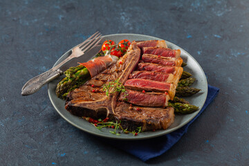Grilled, medium-baked t-bone beef steak. Served with asparagus.