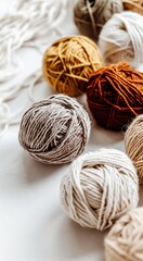Knitting. Balls of cotton and wool yarn in warm tones on a white table. Boho, bed tones, orange, pink, turquoise, hobby