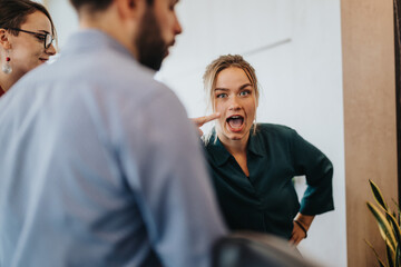 A group of lively business people having an animated discussion in a modern office setting,...