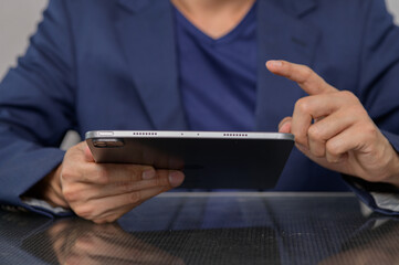 Person in Suit Using Tablet Device for Business or Leisure Purposes