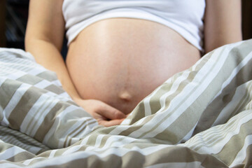 Pregnant woman relaxing in the bed