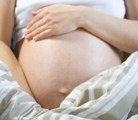 Pregnant woman relaxing in the bed