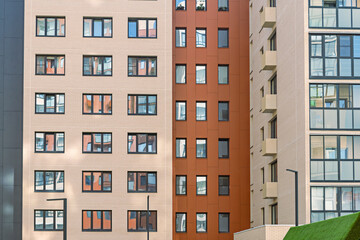 Architectural detail of residential building featuring beige and orange sections with multiple windows